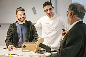 Zwei Studenten und ein Professor im Gespräch